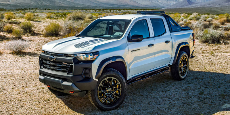 White Chevrolet Colorado pickup truck parked in a desert landscape.